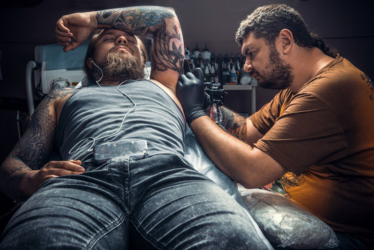 Professional tattooist works in studio