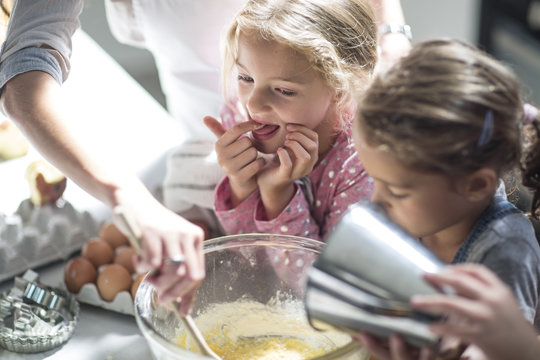 Mother and girls baking in kitchen