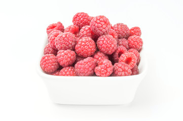 Fresh raspberries in a white bowl.