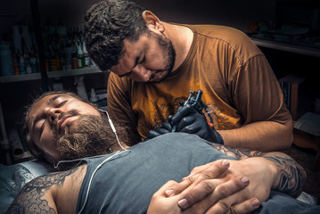 Professional tattooist making a tattoo in studio