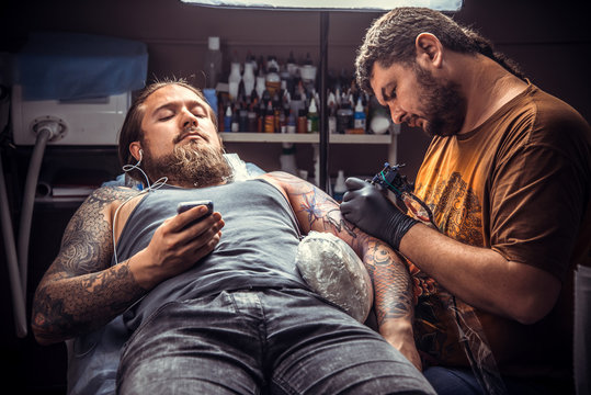 Tattoo master making a tattoo in tattoo studio