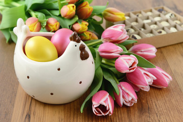 Obraz na płótnie Canvas chicken bowl with easter eggs and bunch of tulips around