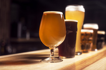 Several different beers are standing in a row at the bar