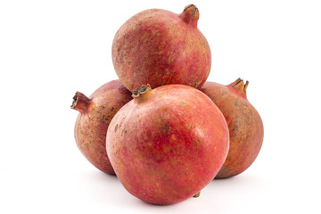 Pile of fresh raw red pomegranates isolated on a white background