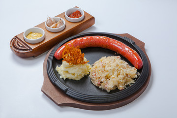 grilled sausage, cabbage and potatoes on cooking pan