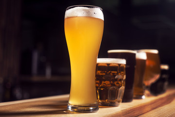 Several different beers are standing in a row at the bar