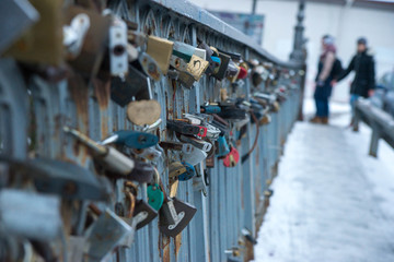 not recognizable couple on the bridge with locks of lovers