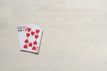 four ten playing cards on light desk. Risk and luck casino game poker abstract with copyspace.