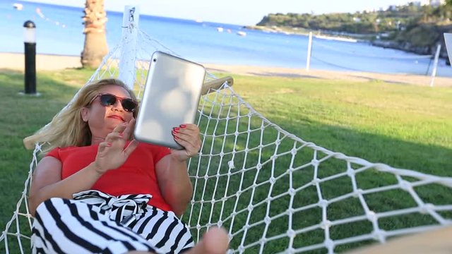 Middle Age  Attractive Blonde Woman Taking Selfie With Digital Tablet on Hammock