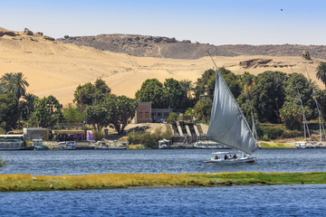 Felucca (river boat) on the Nile, with the Sahara behind in Aswan, Egipt.