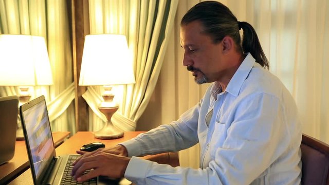 middle age attractive handsome using laptop at home office