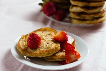Two homemade wholegrain buckwheat pancakes served for eating with strawberries