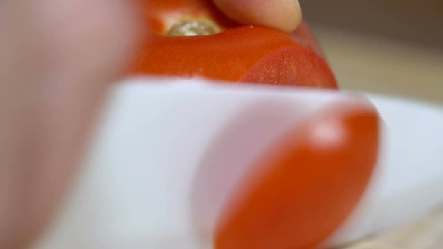 man cuts a tomato for cooking bruschetta
