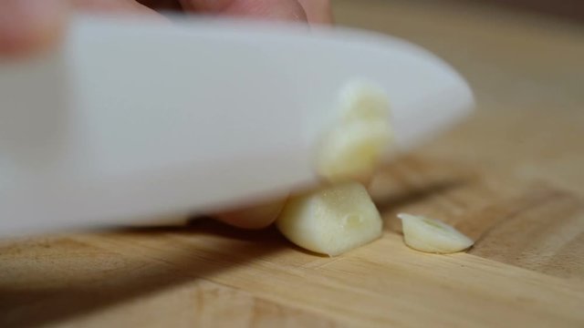 man chopped garlic to prepare bruschetta