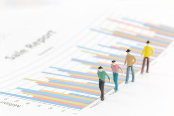 Miniature figures businessman standing on a graph chart