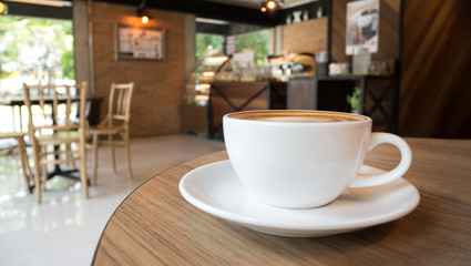 Hot coffee latte cappuccino cup on wooden table in coffee shop