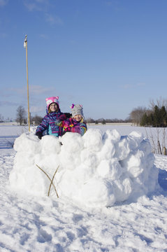 Girls Standing In Large Snow Fort