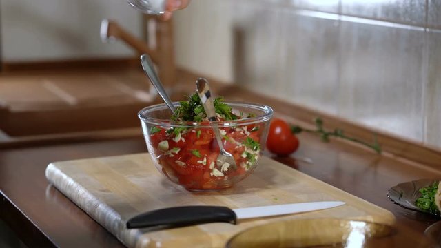 Man mixes ingredients for cooking bruschetta