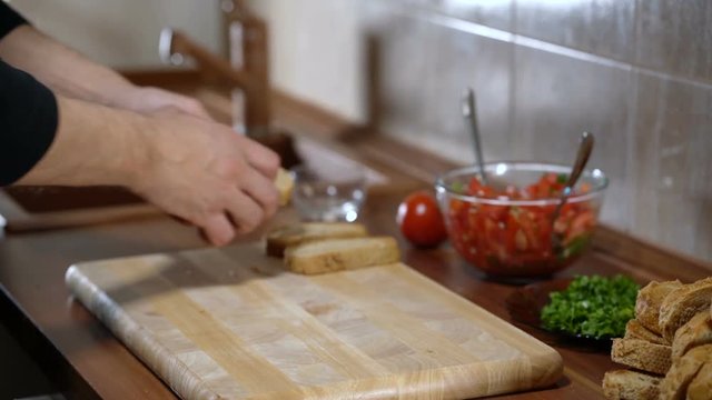 A man arranges bread for cooking bruschetta