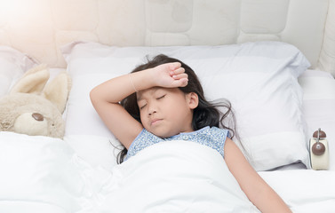 Child lying down suffering from a headache