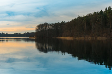 Fototapeta na wymiar Tranquil lake reflecting the trees and sunset