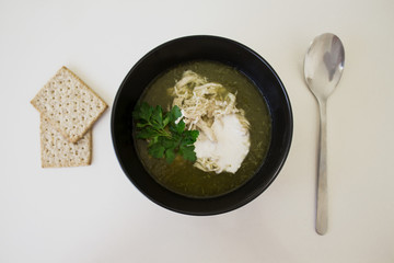 green soup from spinache and brocolli with chicken and crem in the black plate and snacks