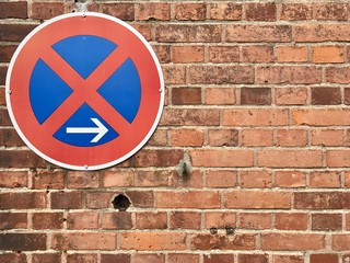 No parking sign on a beautiful rough brick wall