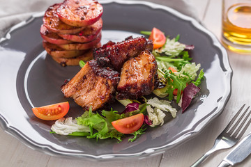 Hot Meat Dishes. Pork ribs grilled with salad and apples on a plate.