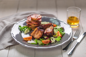 Hot Meat Dishes. Pork ribs grilled with salad and apples on a plate.