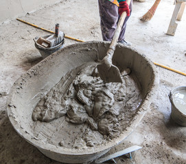 Worker is mixing cement at the construction site
