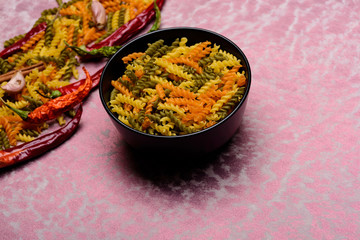 dried fusilli pasta, chilly pepper, garlic in bowl plate