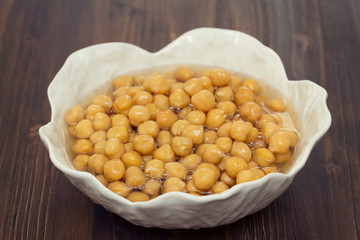 boiled chick-pea in white bowl on wooden background