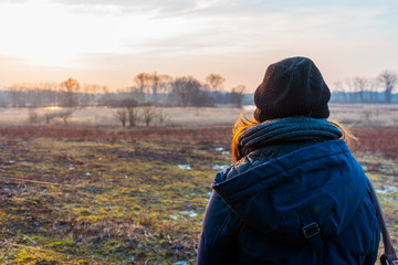 Woman standing looking out over a winter landscape