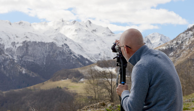 Hiker with camera taking picture of beautiful mountain