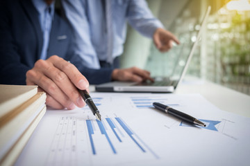 Teamwork process, Businessmen hands pointing at laptop and document during explanation of new plan project data at meeting.