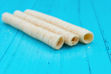 side view sweet egg rolls on blue wood