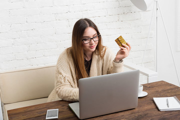 Young woman in glasses online shopping at home
