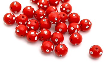 Decorative red beads scattered on white background - accessories for handmade and hobby