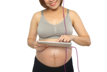 pregnant woman putting headphones on her belly. put some classical music on