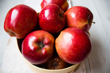 red apples on in wooden bowl