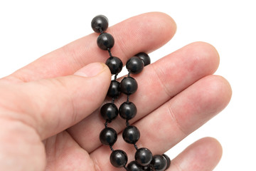 Black beads in hand on a white background