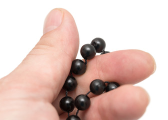 Black beads in hand on a white background