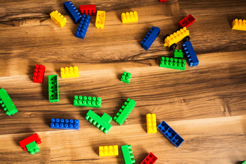 Colorful plastic toy blocks on wooden floor
