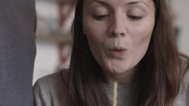 Young adult female blowing out candle on cupcake