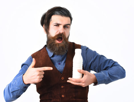 bearded man holding bottle of kefir with happy face