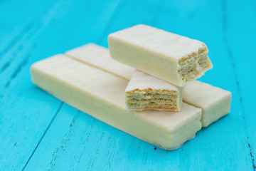 side view white chocolate wafer with cut out sections on a blue background
