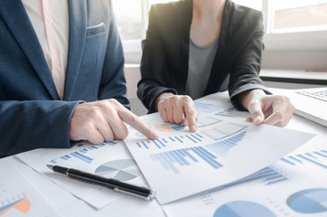 Business team two colleagues discussing financial graph data on office table