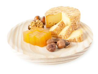 Cheese, hazelnuts, walnut and marmalade on the wooden board