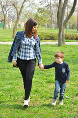 Happy mom and son play in the park in spring. Mother have quality time with her boy at the park