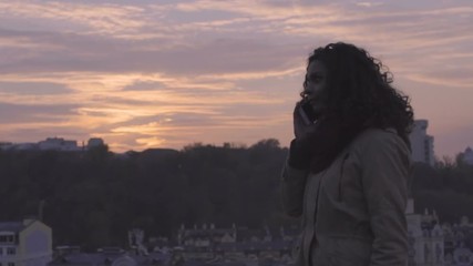 Happy beautiful girl talking over smartphone at sunset, enjoying walk outdoors - Powered by Adobe